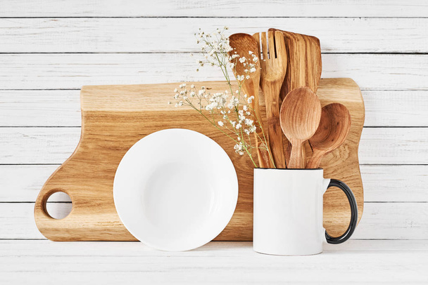 Кухонні інструменти та обробна дошка на білому столі
 - Фото, зображення
