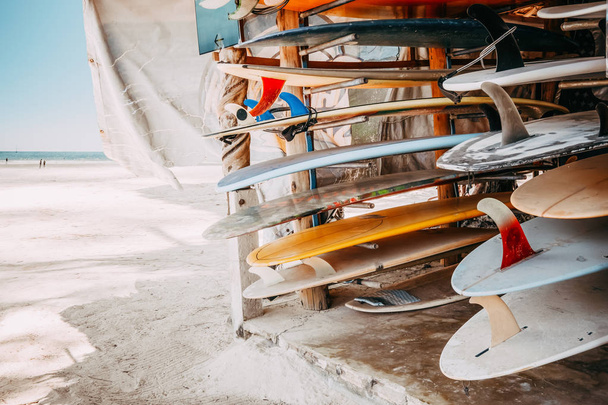 Набор разнообразных красочных досок для серфинга в стеке, доступной в аренду на пляже. Эффект винтажного тона
. - Фото, изображение