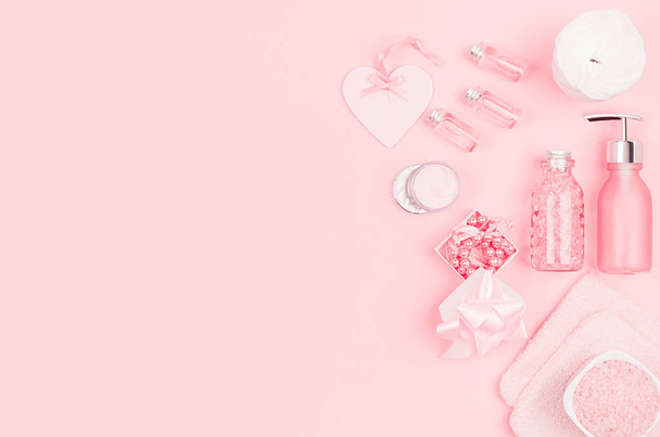 Natural skin care products, accessories for bathroom - cream, salt, essential oil, soap, towel, perfume, pearls, gift, box, bottles, heart, bowl on pink background. - Foto, Imagen