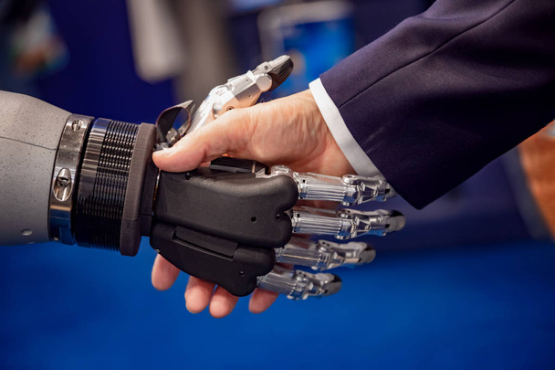 mano de un hombre de negocios estrechando la mano con un robot androide
. - Foto, imagen