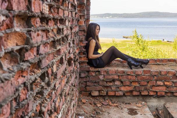 Beleza em vestido curto em ruínas de casa de tijolo e paisagem de verão
 - Foto, Imagem