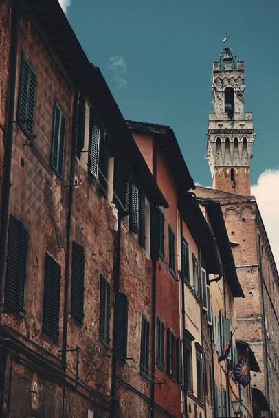 Street view with old buildings and bell tower in Siena, Italy. - Fotografie, Obrázek