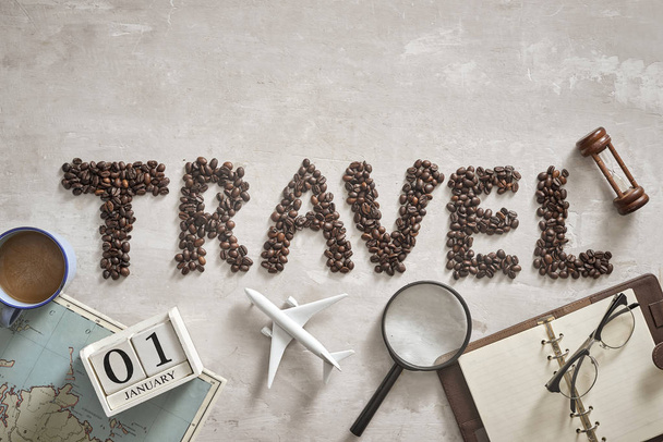 Необходимые вещи для путешественника с письмом из кофейных зерен на полу
 - Фото, изображение