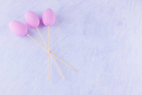 Pink Easter eggs on a stick. Easter minimal concept. Bouquet of eggs on a white background. Flat lay - Foto, imagen