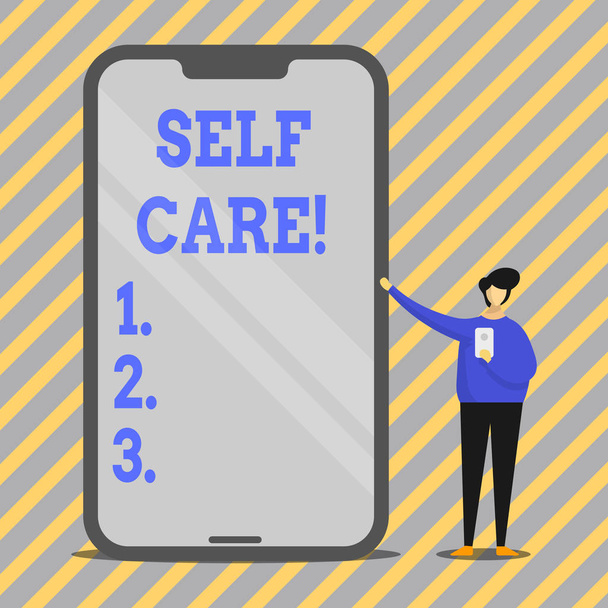 Writing note showing Self Care. Business photo showcasing practice of taking action preserve or improve ones own health Man Presenting Huge Smartphone while Holding Another Mobile. - Photo, Image