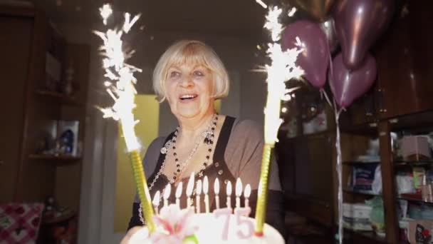 Szczęśliwa kobieta senior gospodarstwa ciasto. Rocznica urodzin w domu - Materiał filmowy, wideo
