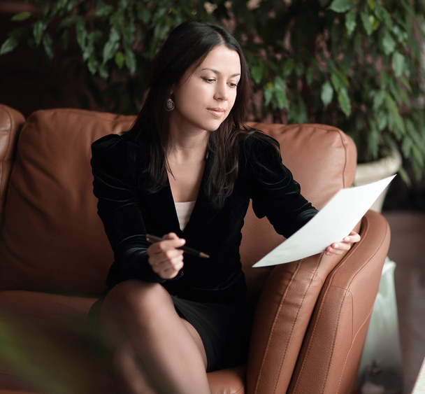 close up. business woman sitting in business center and reading documents - Photo, Image