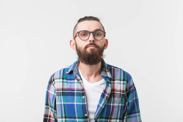Conceito de beleza, moda e pessoas - Retrato de um jovem hipster barbudo elegante sobre fundo branco
. - Foto, Imagem