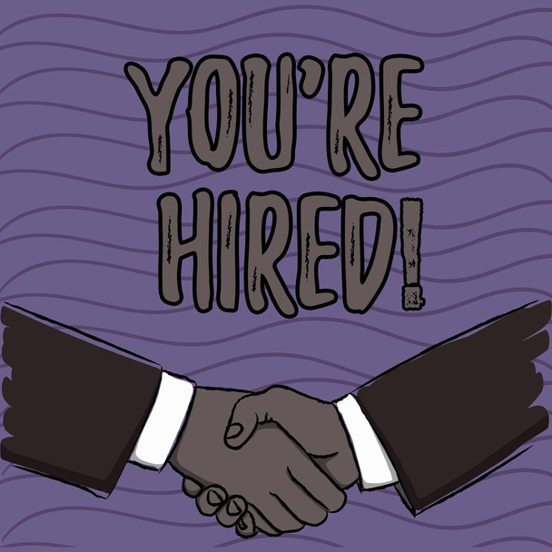 Word writing text You Re Hired. Business concept for Used by huanalysis resources indicate employee that he is got job Businessmen Shaking Hands Firmly as Gesture Form of Greeting and Agreement. - Photo, Image