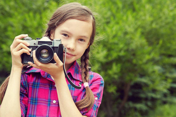 teenage girl with a camera. old photo camera - Foto, afbeelding