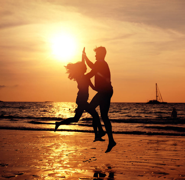 Porträt eines jungen Paares am tropischen Strand, das auf Sonnen posiert - Foto, Bild