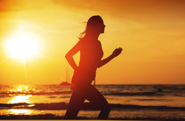 junge athletische Frau läuft an einem tropischen Strand - Foto, Bild