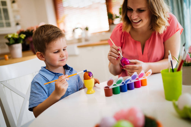 Mother and son are painting eggs. Happy family are preparing for Easter - Foto, imagen