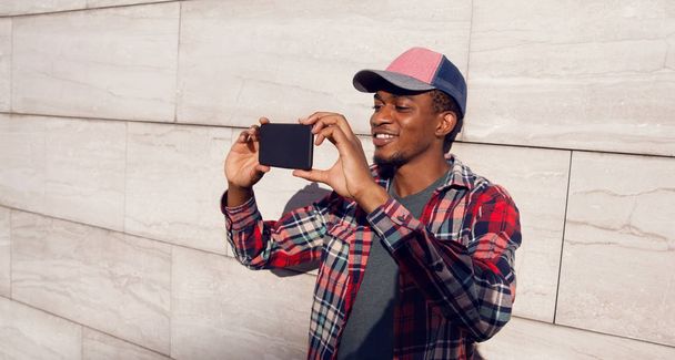Stylish smiling african man taking selfie picture by phone in ba - Foto, immagini