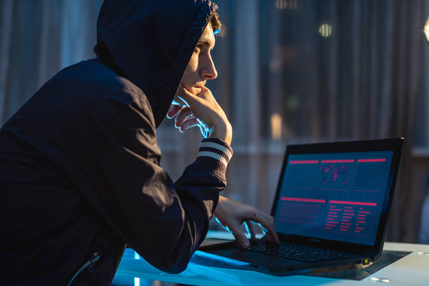 Hacker in der Haube denken über das Problem des Hackens und Diebstahls von Zugangsdatenbanken mit Passwörtern nach. Cybersicherheit - Foto, Bild