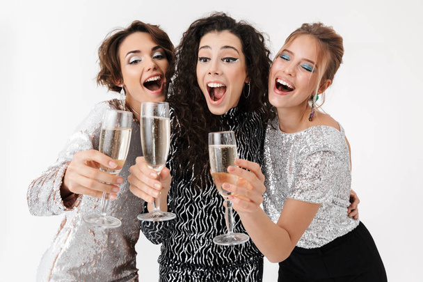 Young happy women friends posing isolated over white wall background. on a party. - Foto, Bild