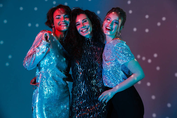 Young happy women posing isolated with disco ball lights. - Foto, Bild