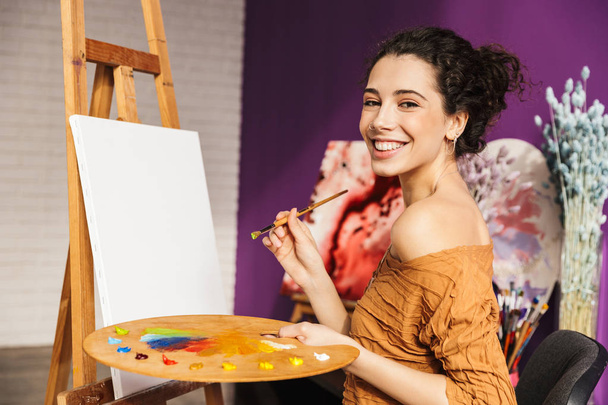 Creative beautiful woman painting at home - Fotó, kép