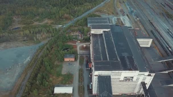 Letecký pohled na obrovské šedé průmyslové budovy blízko železnice a skládce, obklopen lesem. Průmyslová zóna shora. - Záběry, video