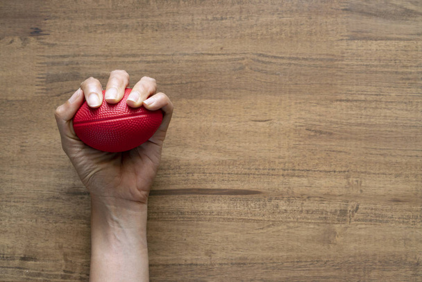 woman hand holding stress ball on wood table background  - Valokuva, kuva