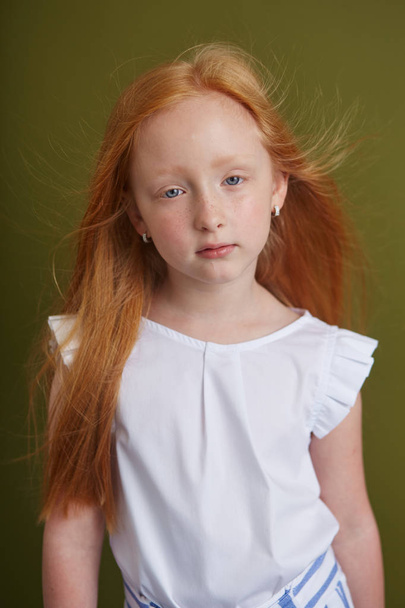 Young red-haired girl with long beautiful hair and big blue eyes - Foto, Imagen