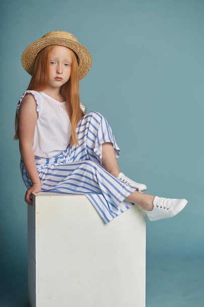 Young red-haired girl in a straw hat with long beautiful hair an - Foto, afbeelding