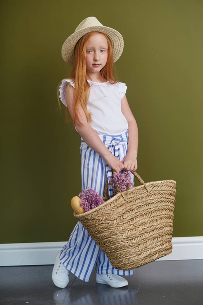 Young red-haired girl in a straw hat with long beautiful hair an - Fotografie, Obrázek