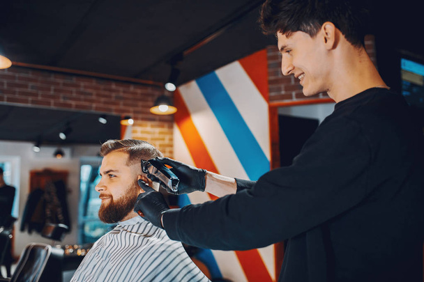 Stylish man sitting in a barbershop - Foto, Bild