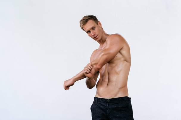 Sexy athletic man with naked torso on white background. Fashion portrait of sporty healthy guy - Valokuva, kuva