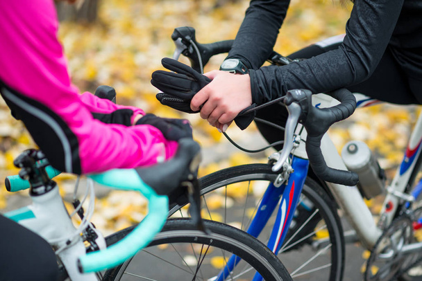 Two Young Female Cyclists with Road Bicycles Resting in the Park in Cold Autumn Day. Healthy Lifestyle. - Zdjęcie, obraz