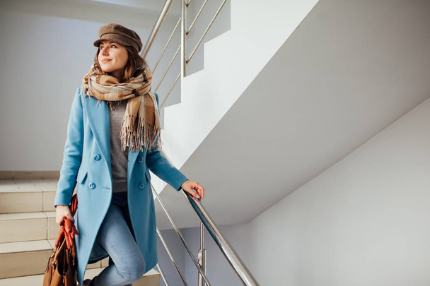 Obchodní žena v kabátě, která chodí po schodech do obchoďáku. Nákupní. Módní - Fotografie, Obrázek