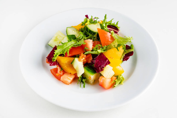 vegetable salad on the white plate - Фото, изображение