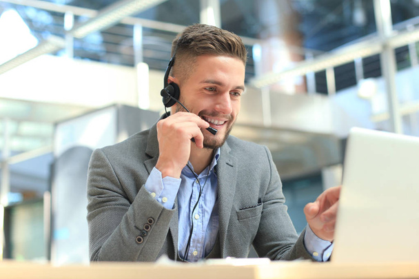 Smiling friendly handsome young male call centre operator. - 写真・画像