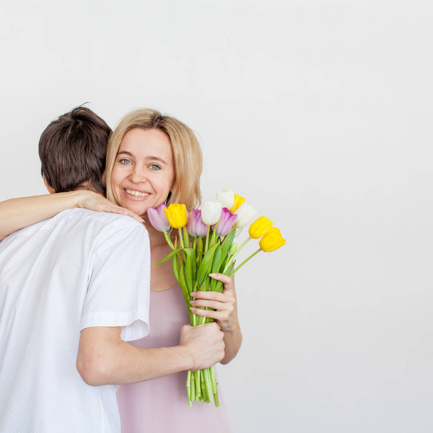 Oğlu anne tatil için bir buket çiçek verir - Fotoğraf, Görsel