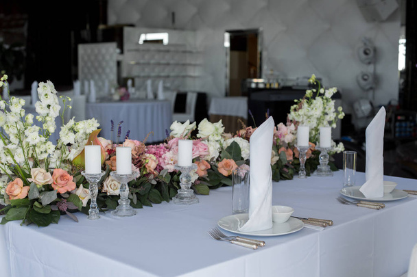 столу молодят в прикрасі ресторану свіжі квіти та свічки. Прикраса весіль свіжими квітами
 - Фото, зображення