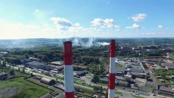 道路の近くの赤と白のストライプ煙突と工場のクローズ アップ。映像。上から工業地帯 - 映像、動画