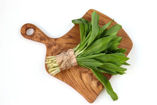 ramson wild garlic on a wooden board on a white background - 写真・画像