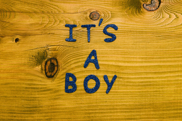 Text it's a boy on wooden table.Toned photo. - 写真・画像
