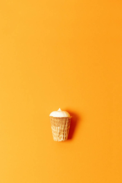lágy fagylalt, vagy fagyasztott puding a kúp elszigetelt narancssárga háttér - Fotó, kép
