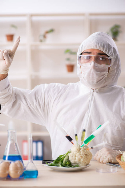 Вчений, що працює в лабораторії на фруктах і овочах GMO
 - Фото, зображення