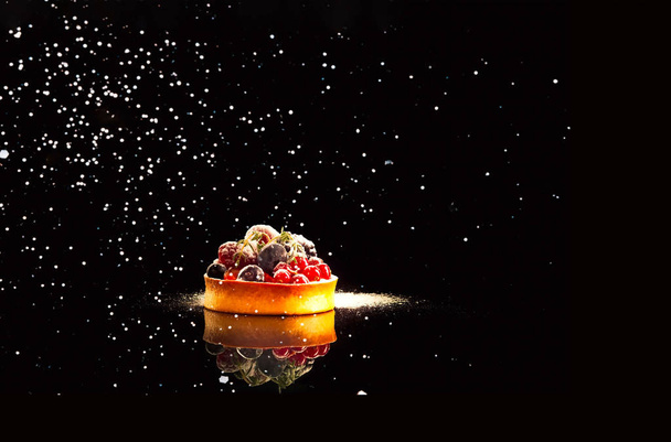 Cupcake and berries with reflection on black background - Φωτογραφία, εικόνα