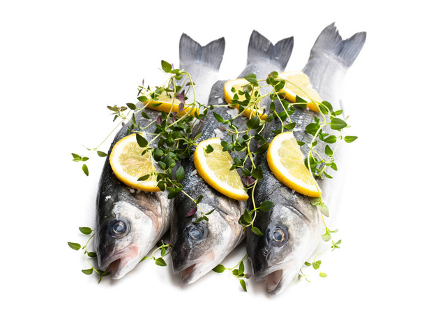 Fresh whole sea bass fish with lemon and spices isolated on a white  - Photo, Image