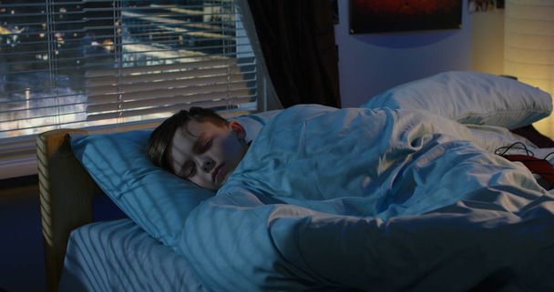 jongen slapen in zijn bed - Foto, afbeelding