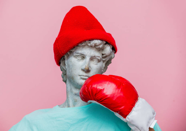 Antieke buste van man in de hoed met Bokshandschoen op roze achtergrond. Klaar voor de zomervakantie - Foto, afbeelding
