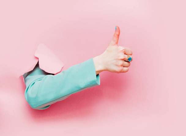 Жіноча рука в класичному синьому піджаку показує ОК символ виглядає з рожевого фону
 - Фото, зображення