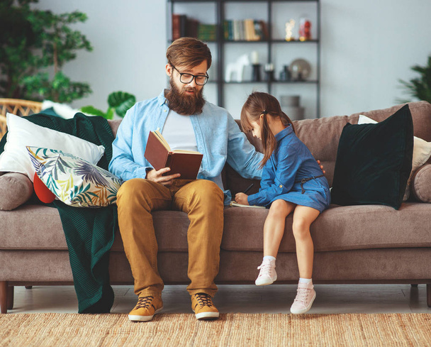 happy family. father reading a book to a child daughter at home  - Photo, Image