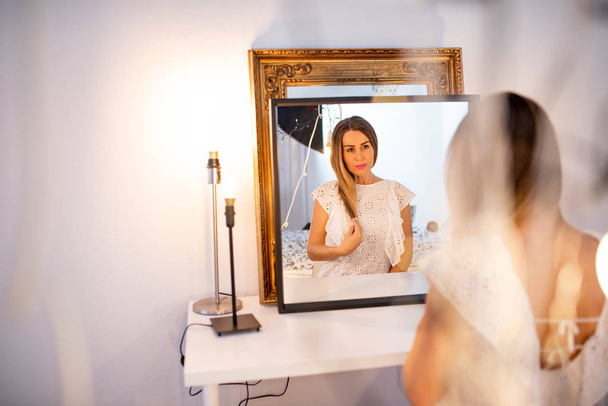 Portrait of a mature woman in front of a mirror - Fotó, kép