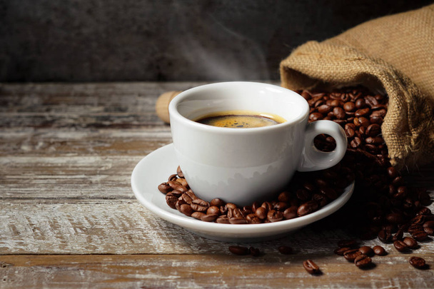 xícara de café e grãos de café na mesa de madeira - Foto, Imagem