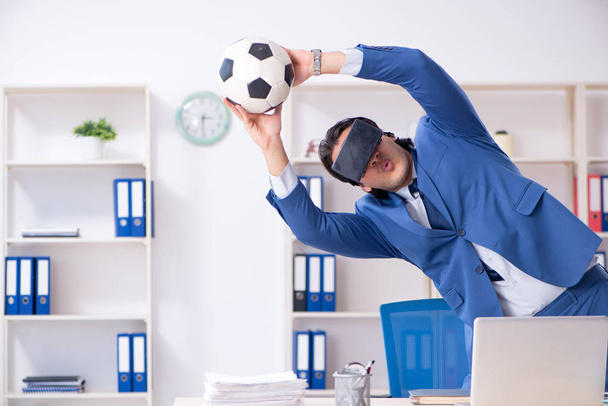 Young handsome businessman playing soccer with virtual glasses  - Photo, Image