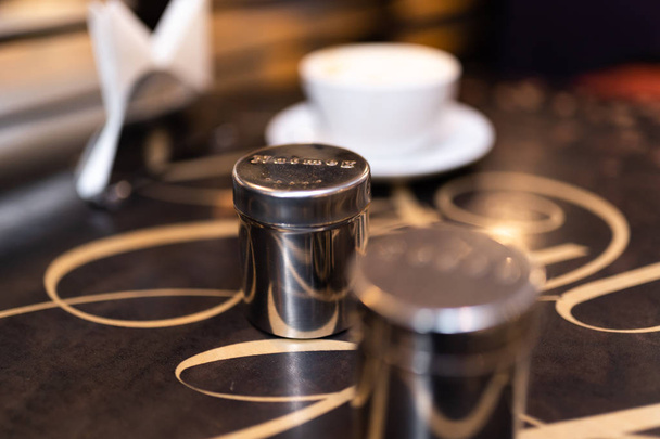 Tazza di caffè con sale e pepe shaker sul tavolo in caffetteria
 - Foto, immagini